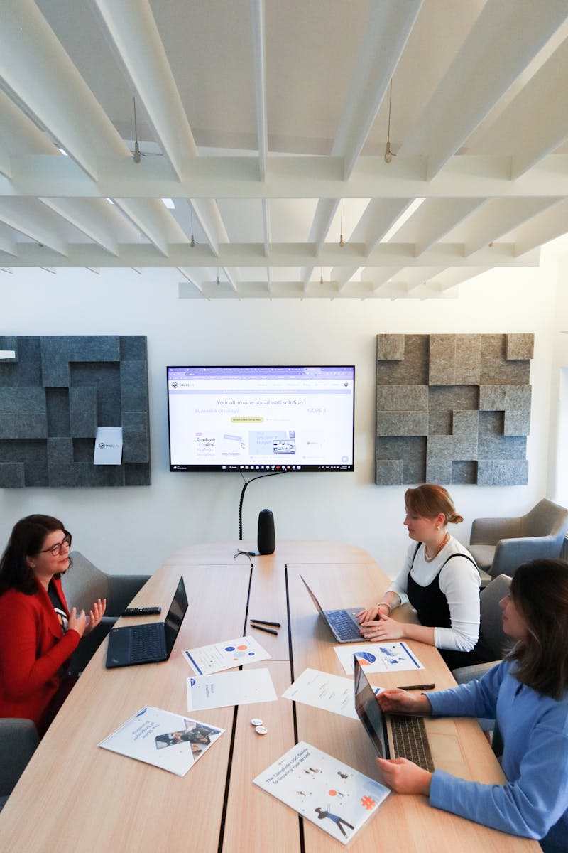Women collaborating in a modern office, engaging in teamwork and technology discussions.