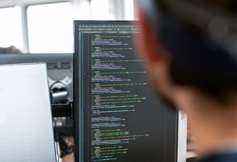 A male software engineer working on code in a modern office setting.