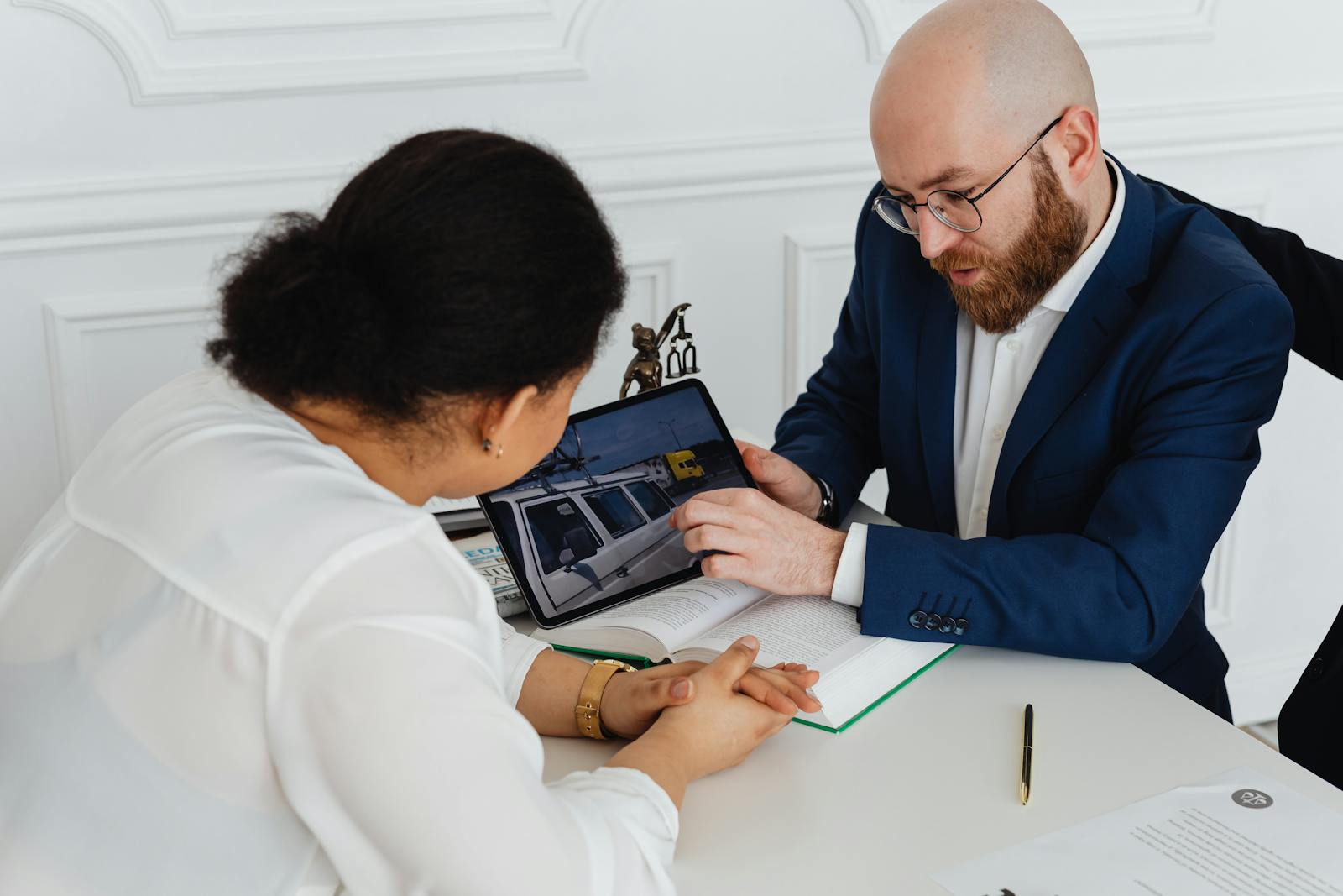 Man and woman in a professional office meeting discussing a project with digital presentations.