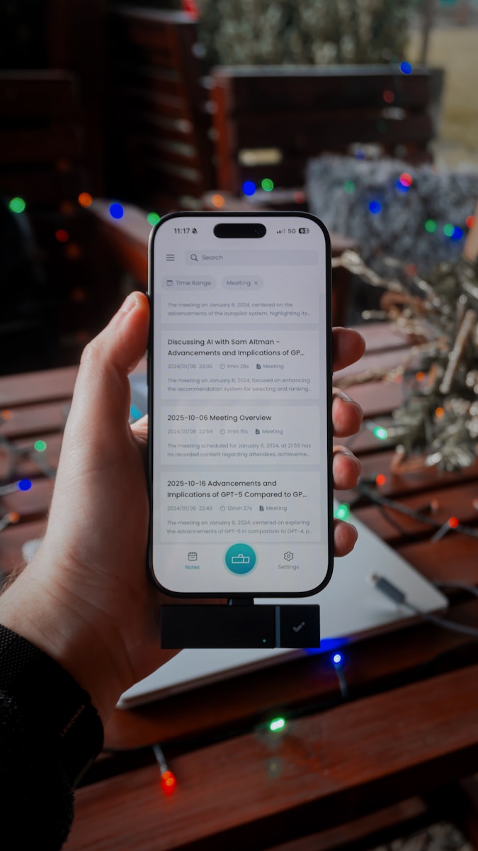 Hand holding smartphone displaying notes app outdoors.
