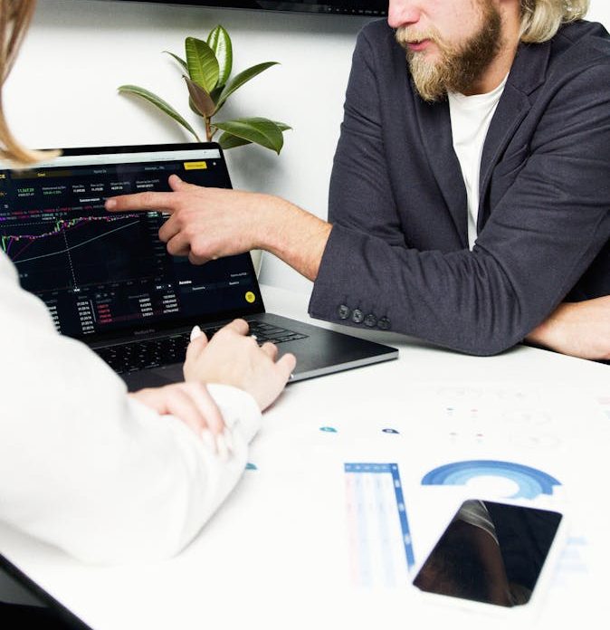 Professionals discussing financial charts and graphs during a business meeting.