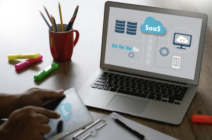 A laptop and tablet displaying cloud-based SaaS infrastructure, databases, and connected digital services, representing the technology behind a custom web application.