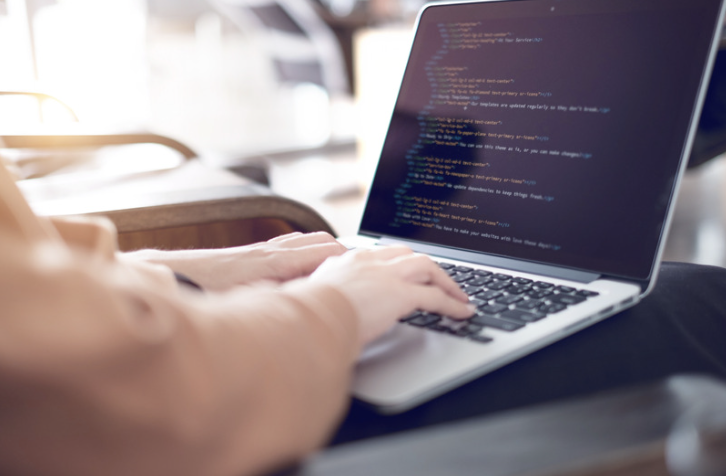 A developer typing code on a laptop, representing the tools, frameworks, programming languages, and platforms that form a web development technology stack for building, testing, and maintaining modern websites and web applications.